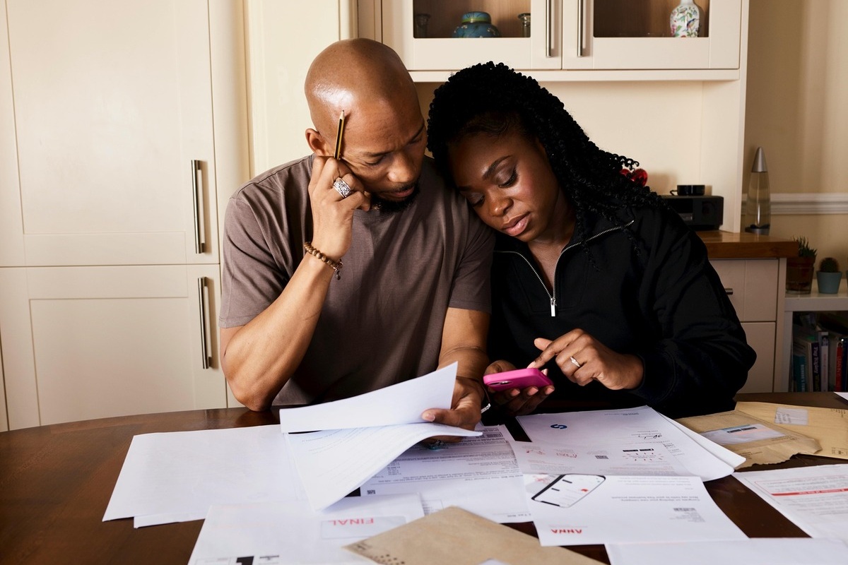 Learn to Invest - The Institute of Trading & Investing is dedicated to educating busy parents and professionals on effective wealth building (211) Working mother checking investment returns on smartphone while caring for young child